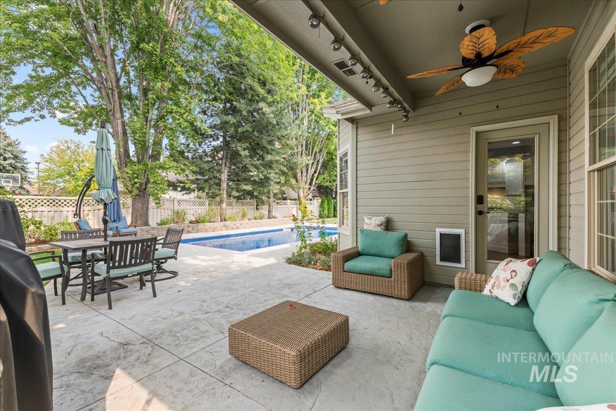 Fenced backyard featuring a patio, ceiling fan, outdoor lounge area, and outdoor dining area