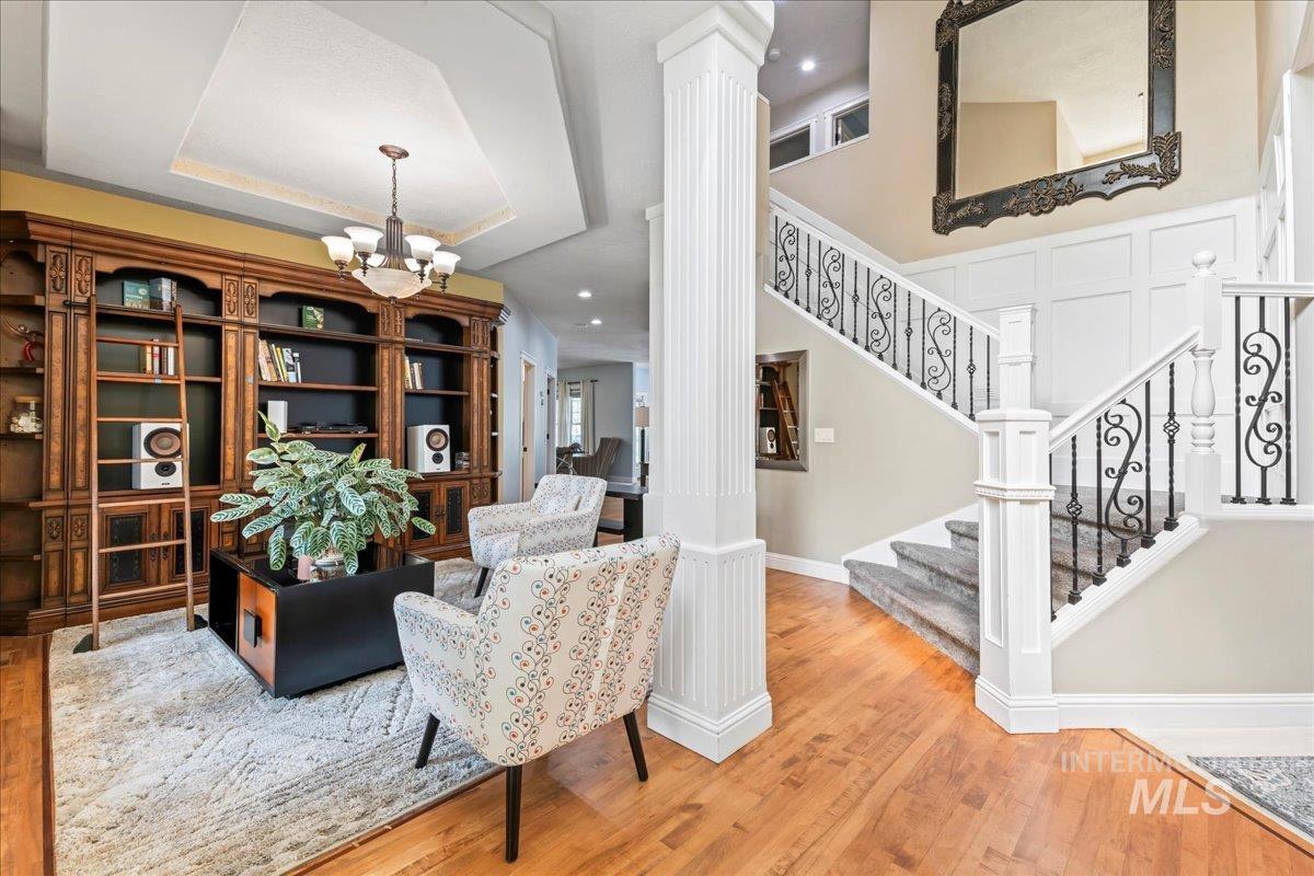 Foyer entrance featuring wood finished floors, a chandelier, and a raised ceiling