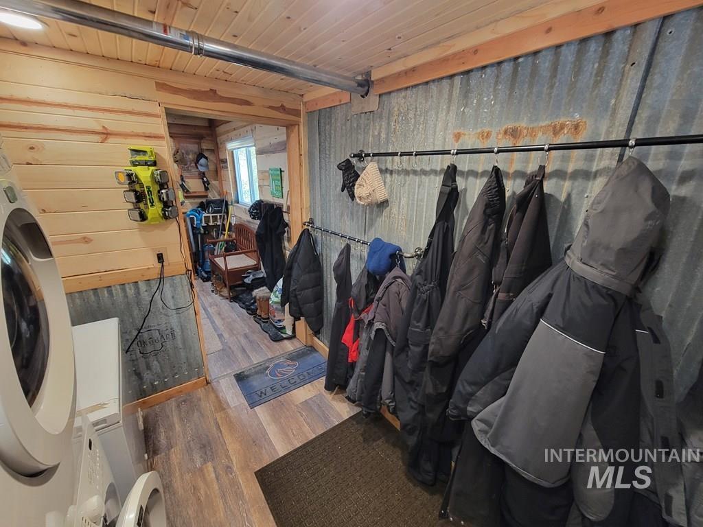 Mudroom with wooden walls, wood finished floors, washer / dryer, and a wood ceiling with exposed beams