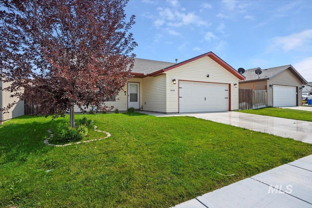 View of front of property featuring concrete driveway and a garage
