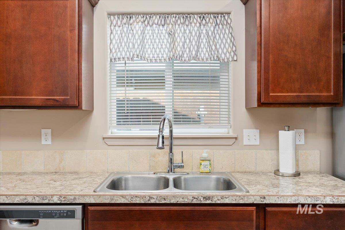 Kitchen with light countertops and stainless steel dishwasher
