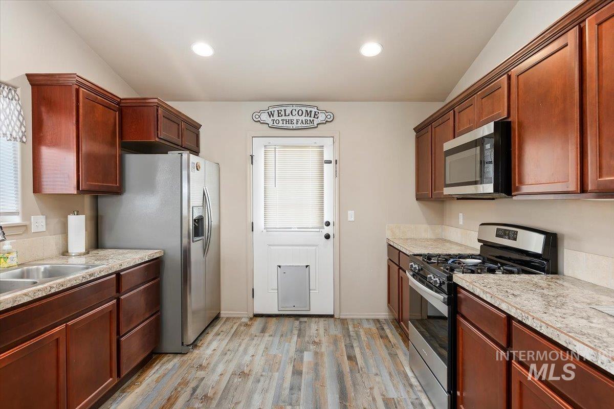 Kitchen featuring appliances with stainless steel finishes, light wood finished floors, and recessed lighting