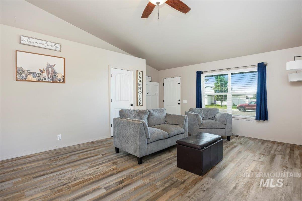 Living area featuring lofted ceiling, ceiling fan, and wood finished floors