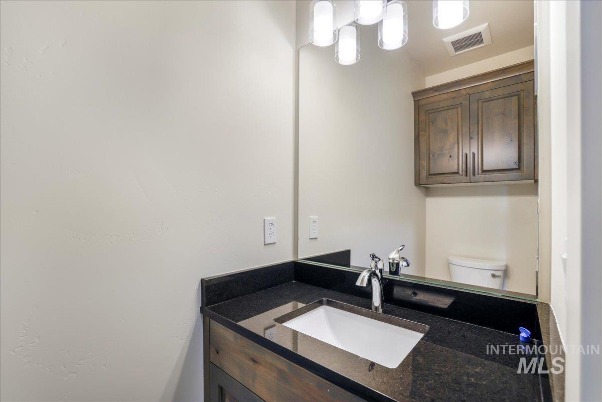 Half bathroom featuring vanity and toilet