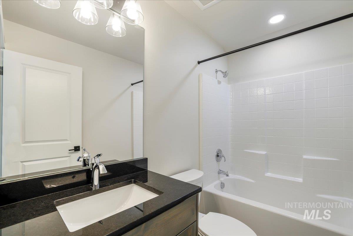Bathroom featuring shower / washtub combination, vanity, and recessed lighting