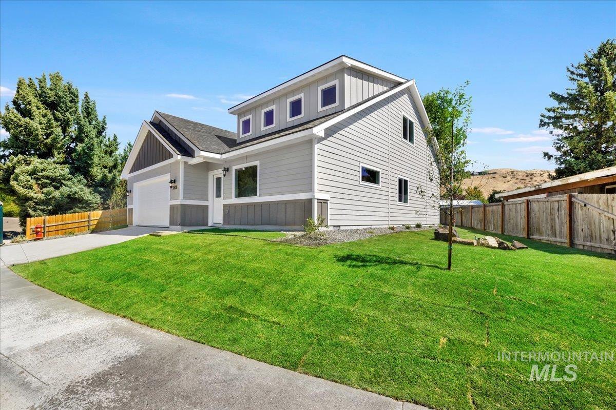 View of front of home with driveway, board and batten siding, and a garage