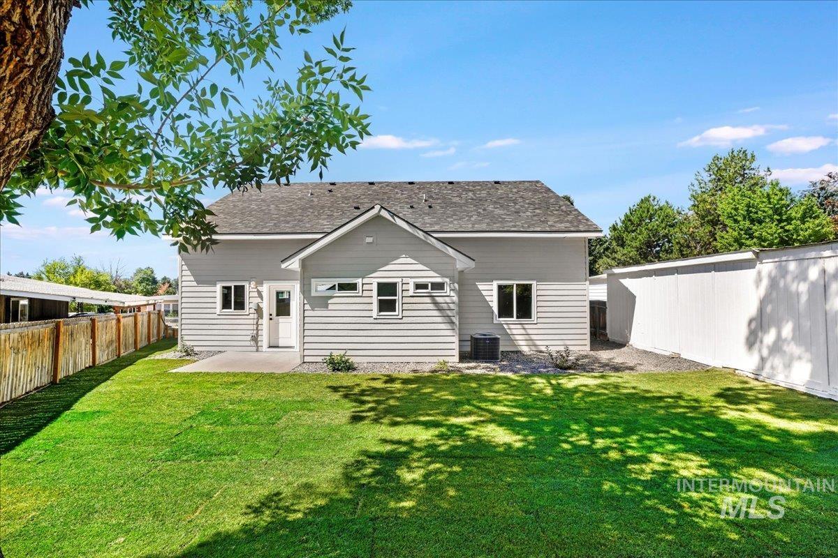 Back of property featuring a patio, a fenced backyard, and roof with shingles