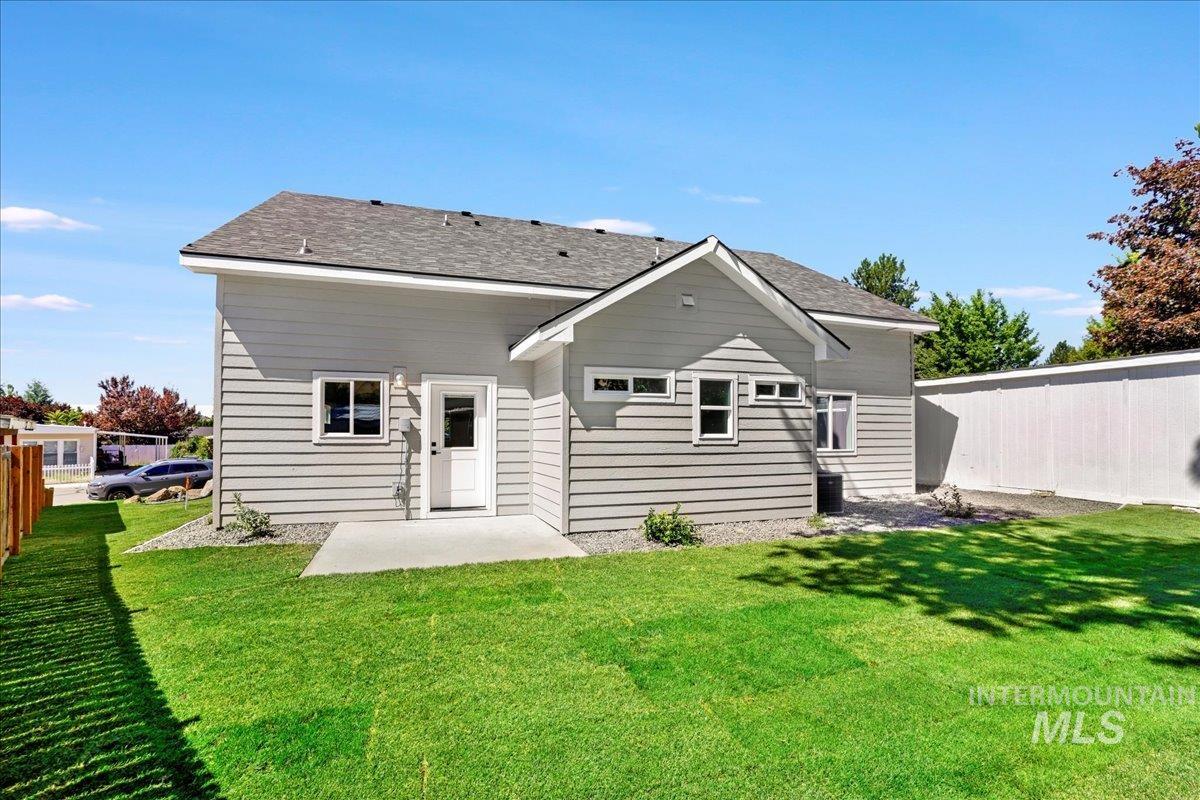Back of property with a patio area and roof with shingles