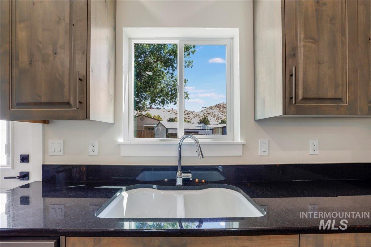 Kitchen with dark stone counters and a sink