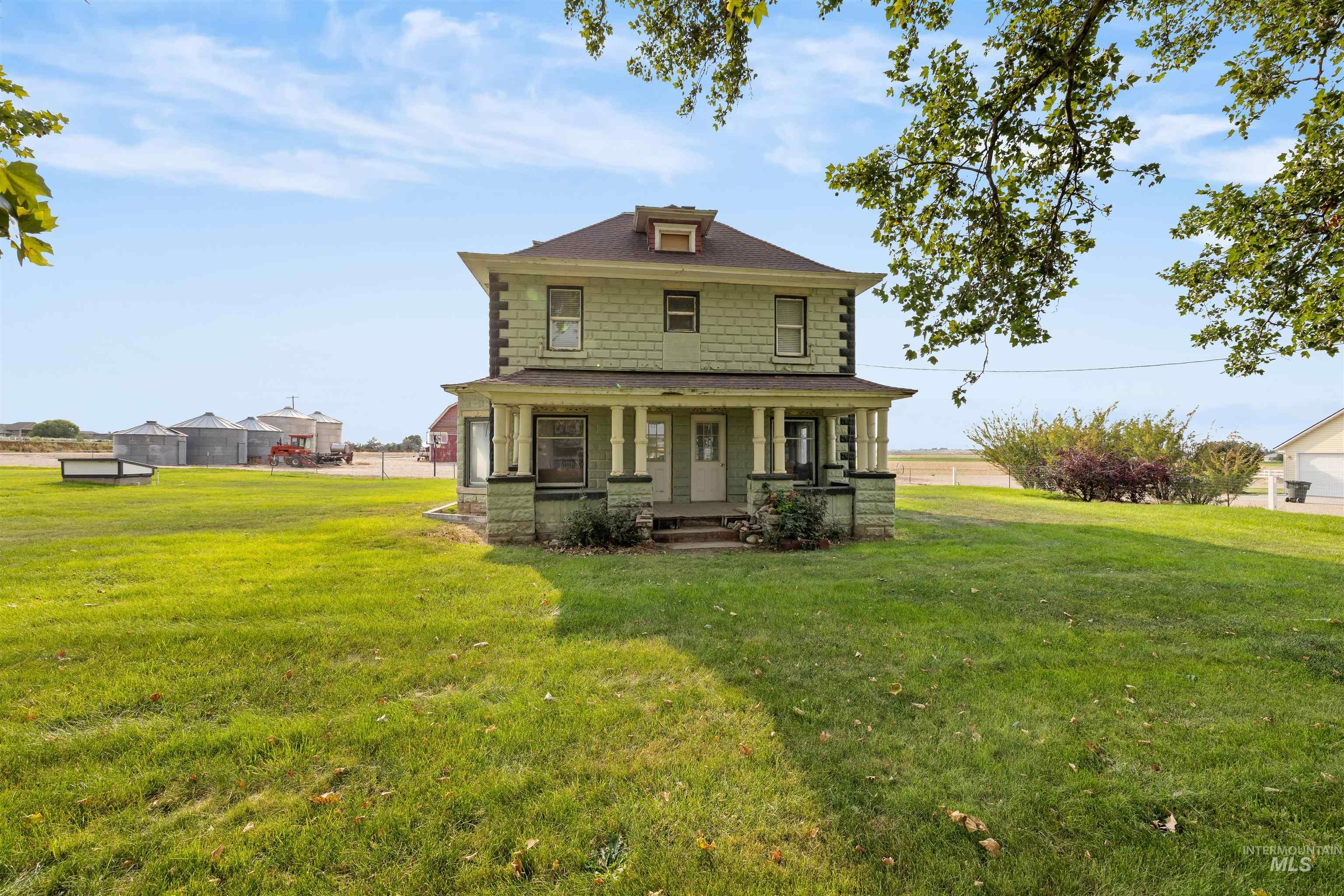American foursquare style home featuring covered porch and a front yard