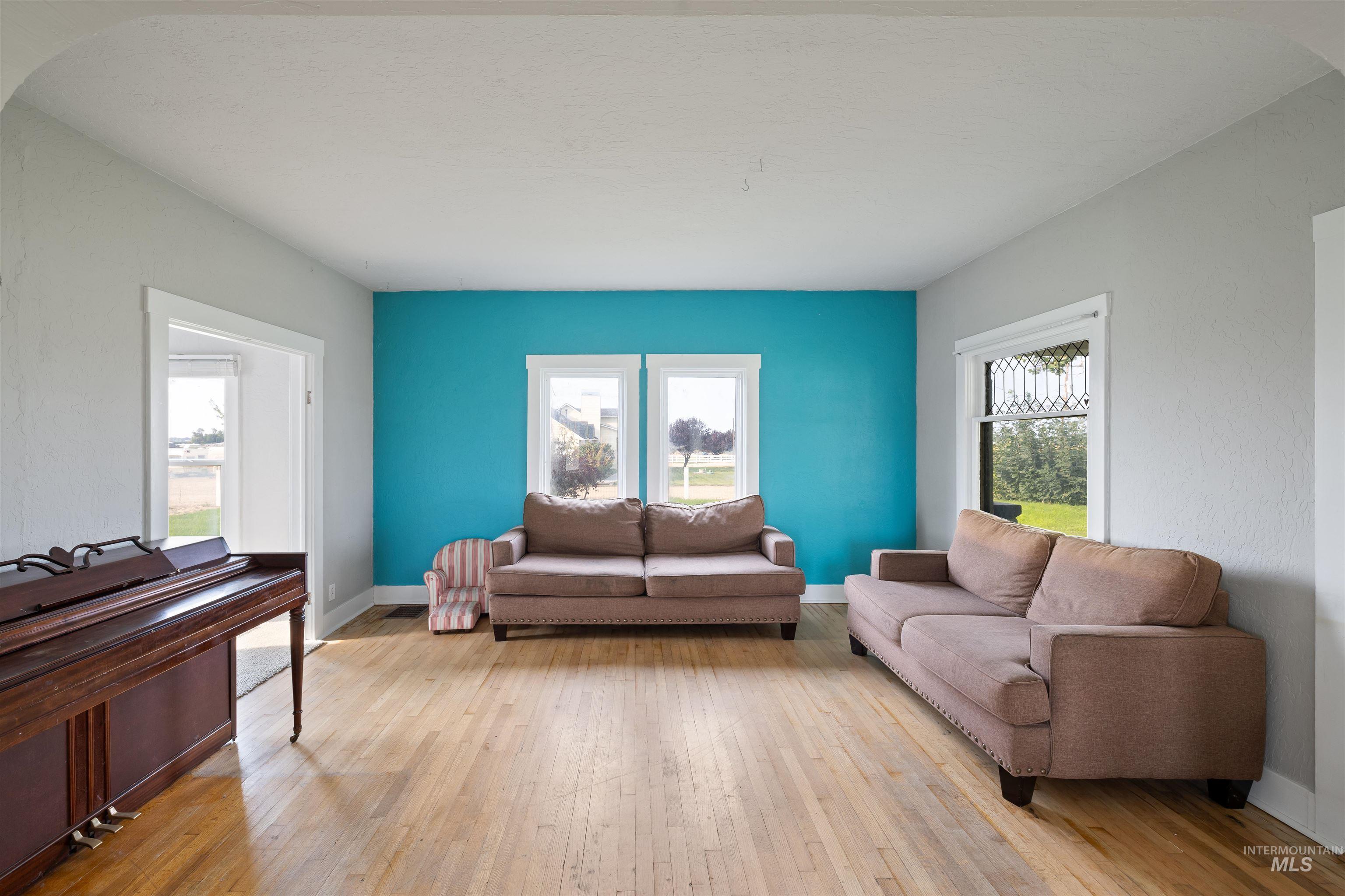 Living area with light wood-type flooring and arched walkways