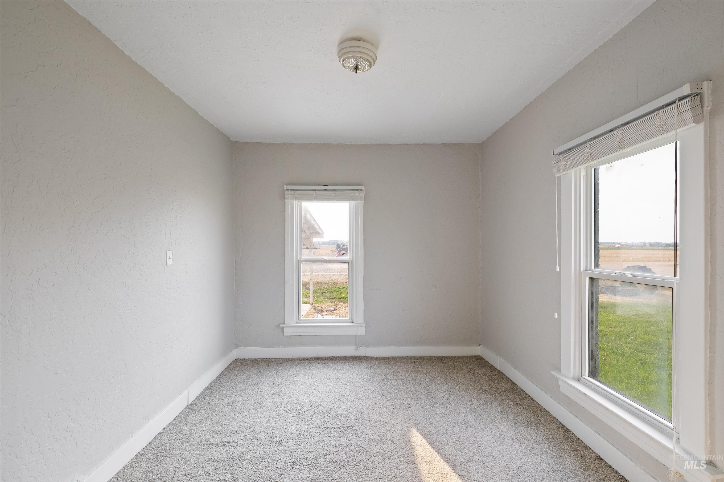 Unfurnished room featuring light colored carpet and baseboards