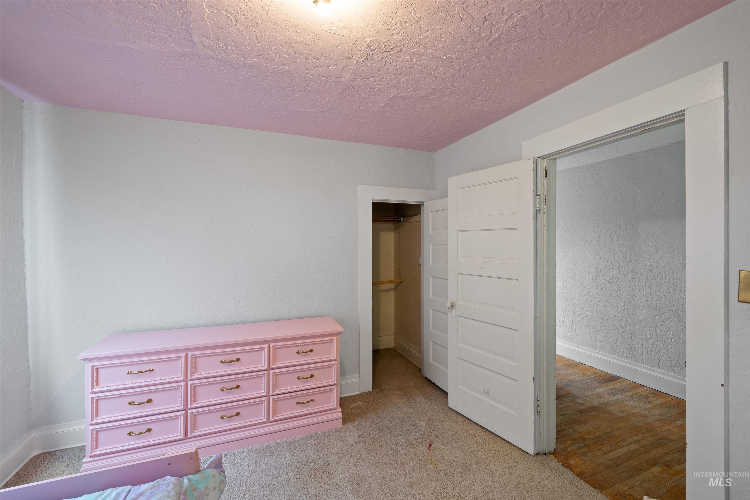Bedroom featuring a textured ceiling and light colored carpet