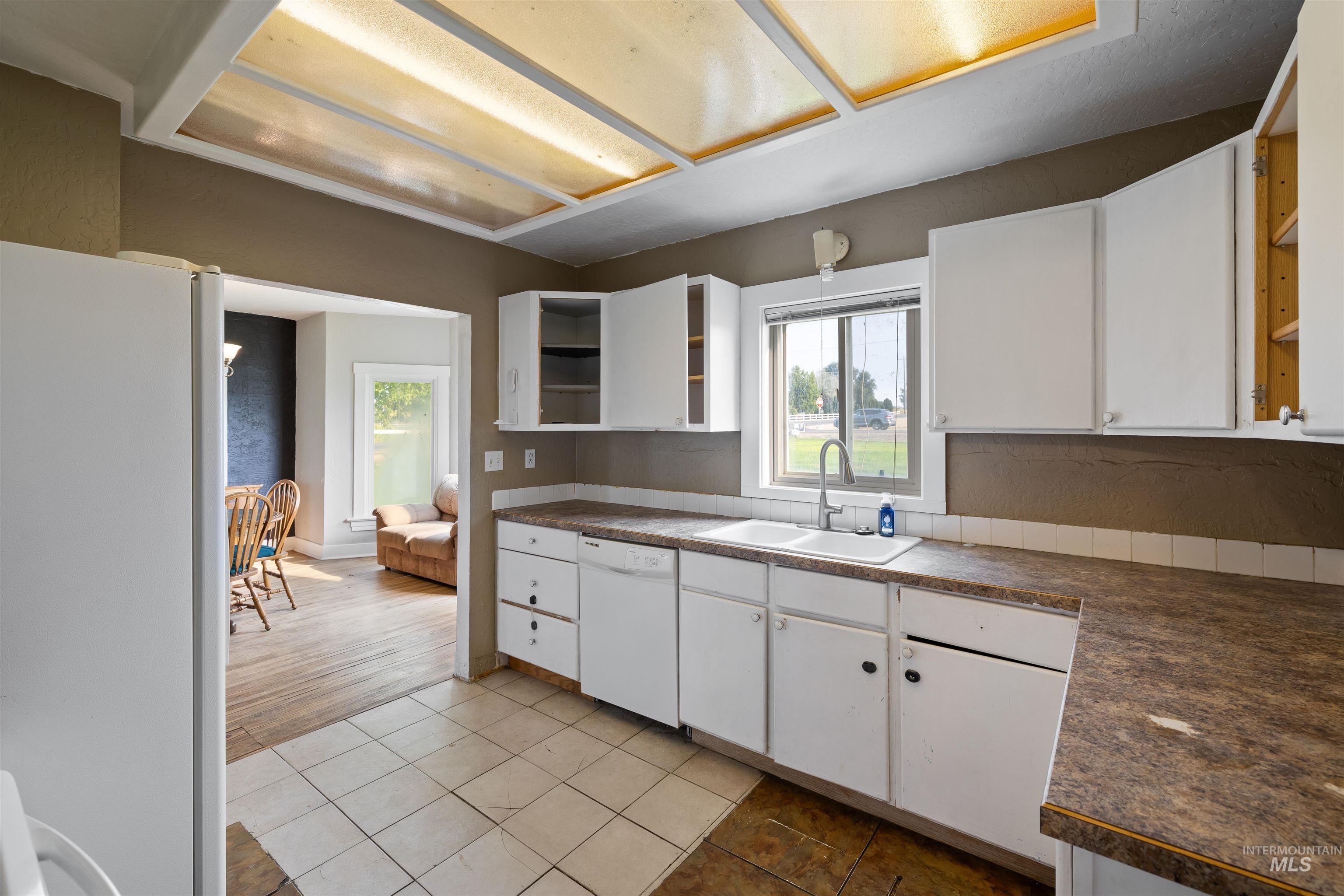 Kitchen featuring open shelves, white cabinetry, white appliances, and light tile patterned floors