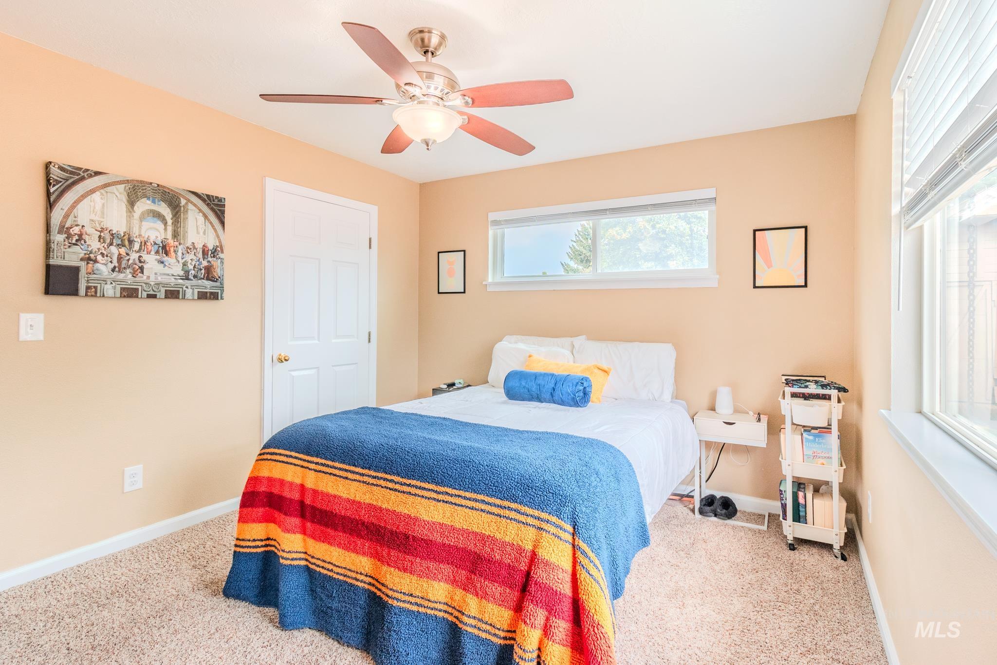 Carpeted bedroom featuring baseboards and a ceiling fan