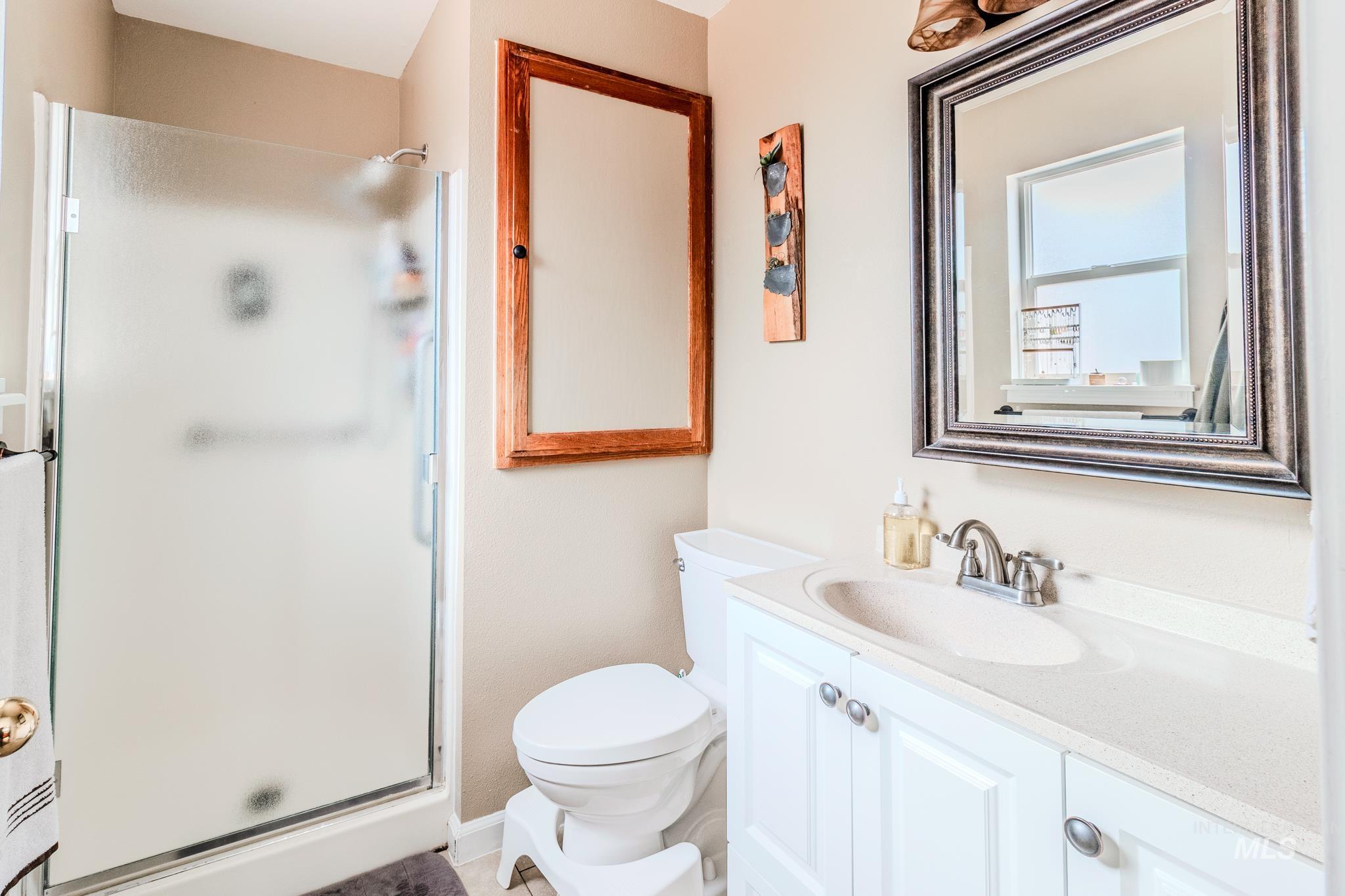 Full bath featuring a stall shower and vanity