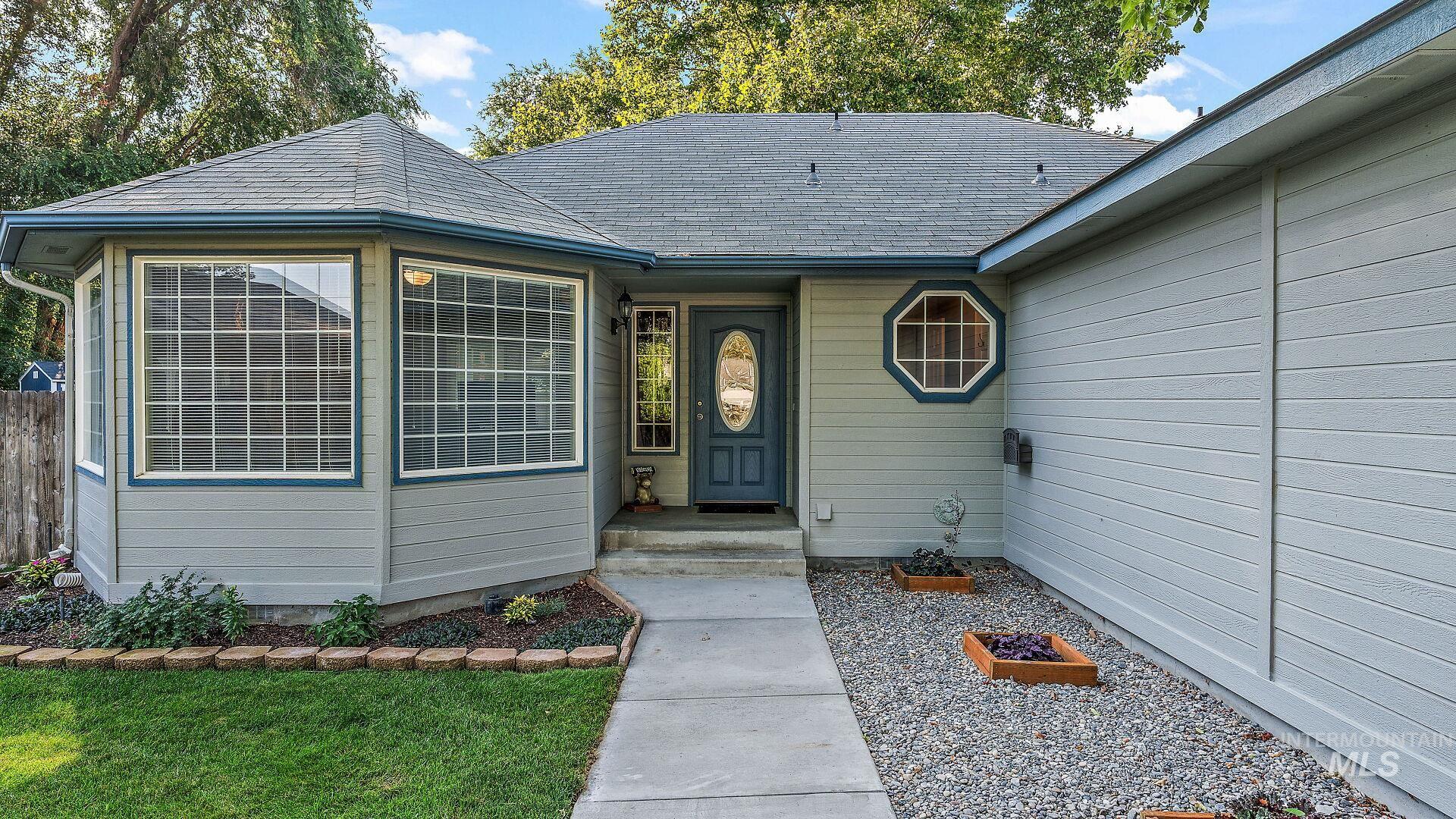 Property entrance featuring a shingled roof and a lawn
