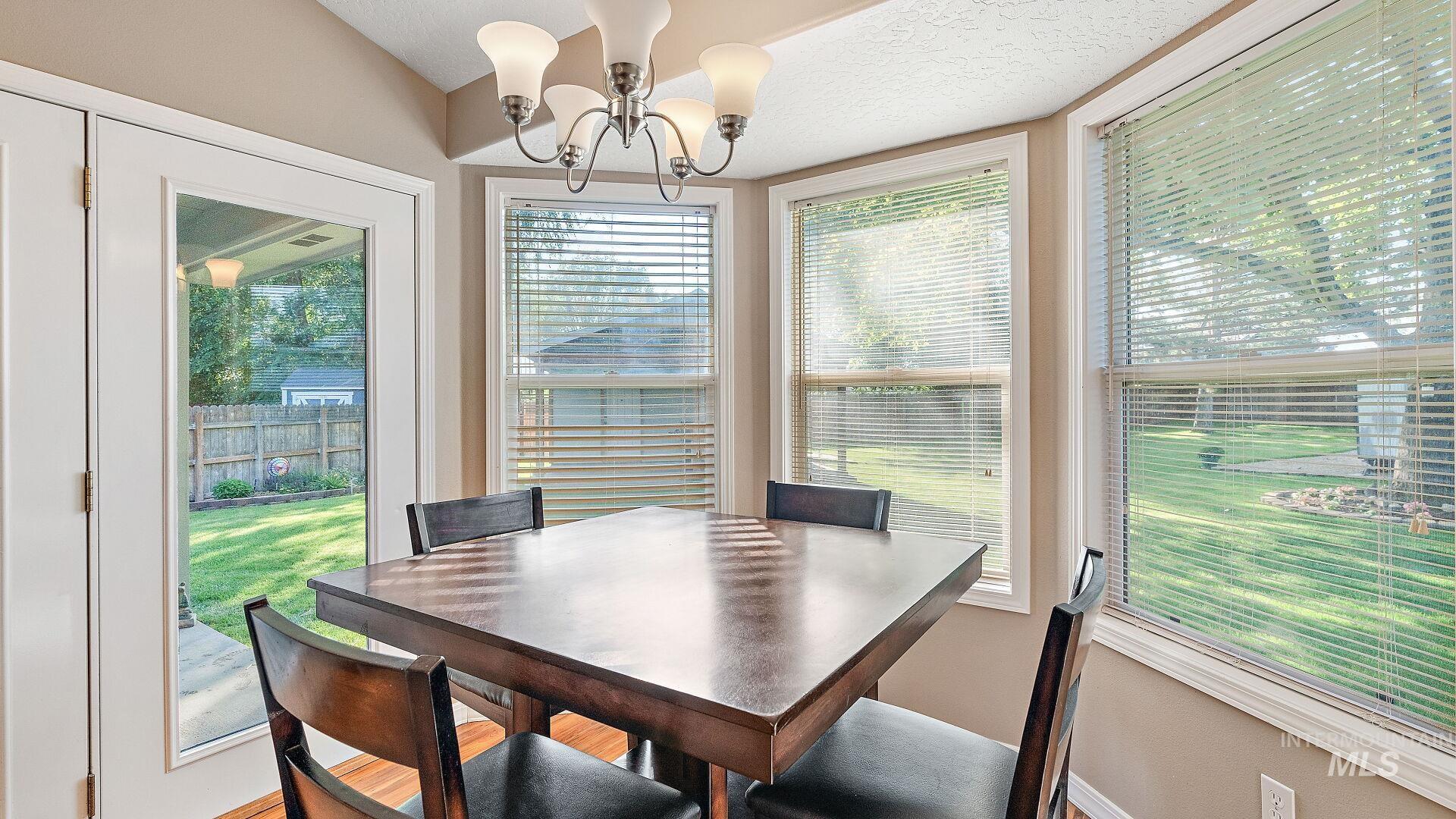 Dining area featuring plenty of natural light, a chandelier, and a textured ceiling