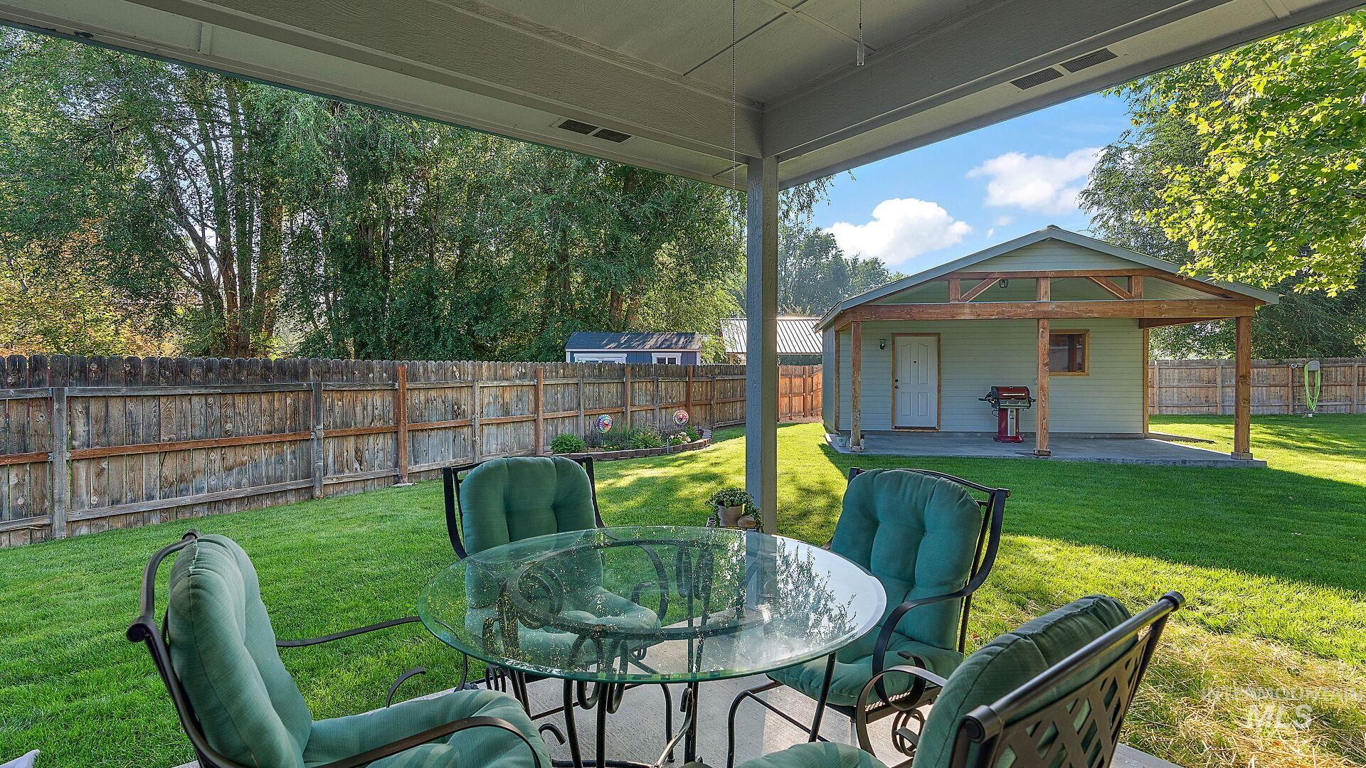 Fenced backyard with a patio, a grill, and outdoor dining space