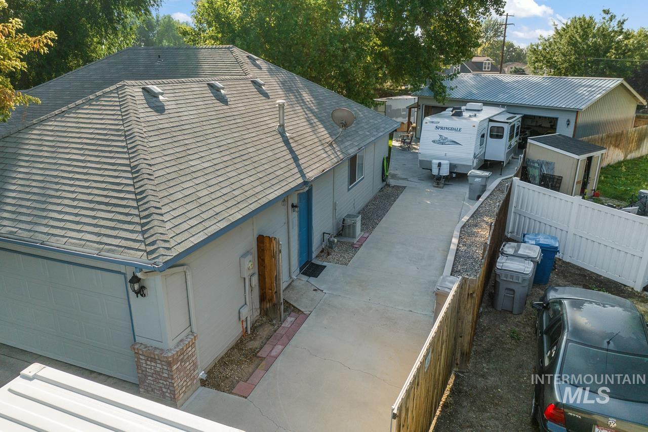 View of property exterior featuring a garage and a shingled roof