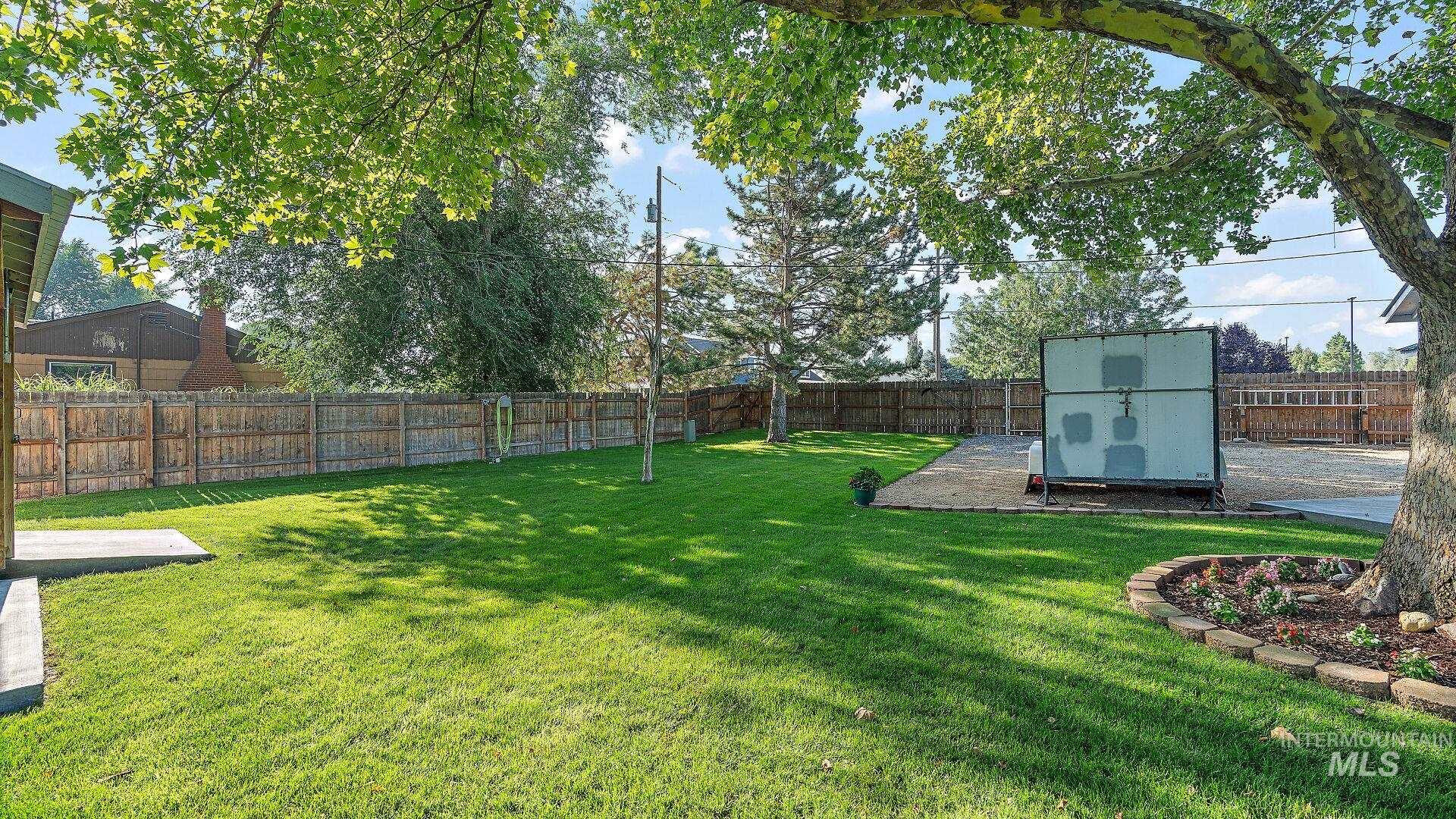 Fenced backyard featuring a storage shed and a patio area