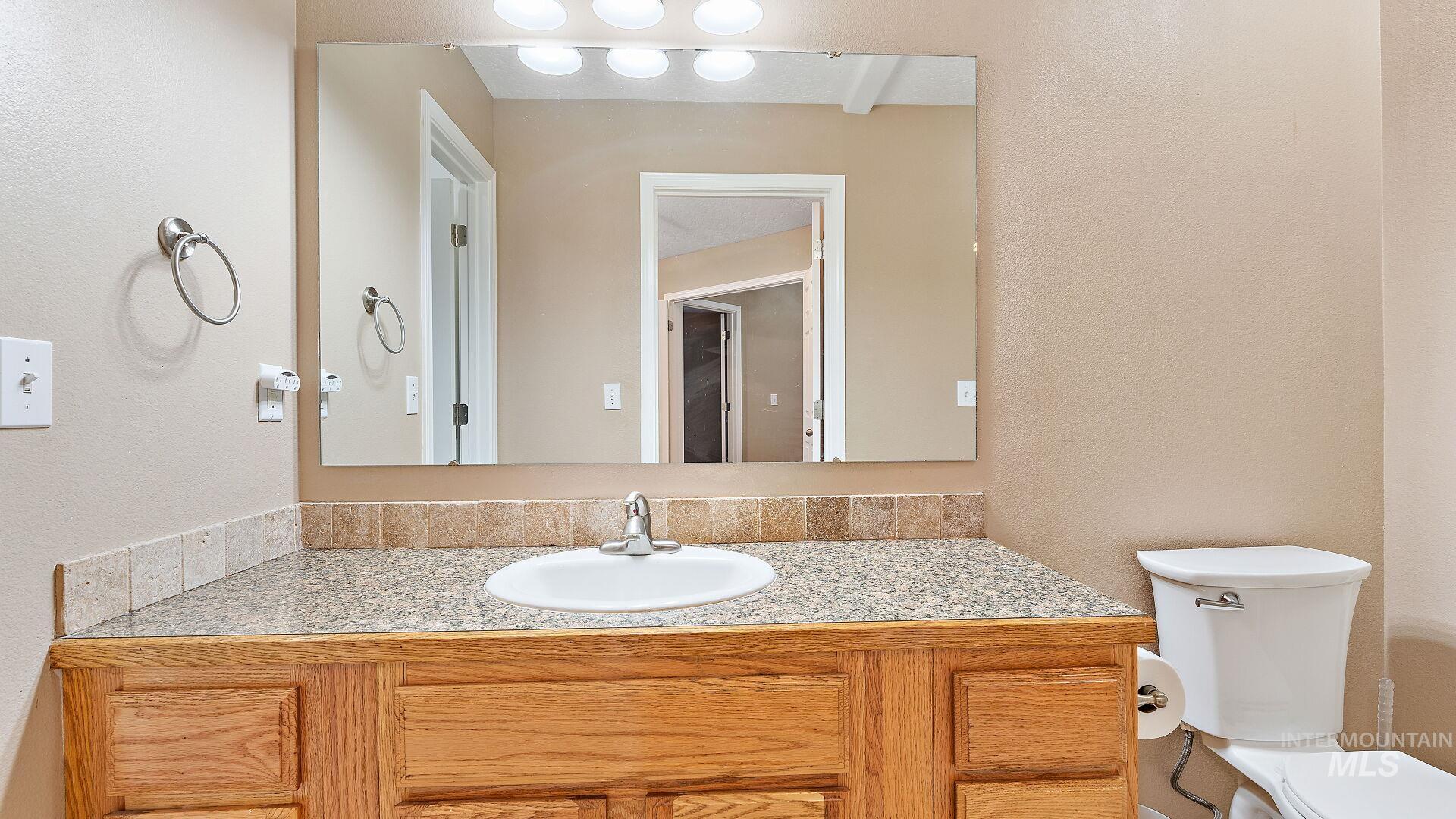 Bathroom with a textured wall and vanity