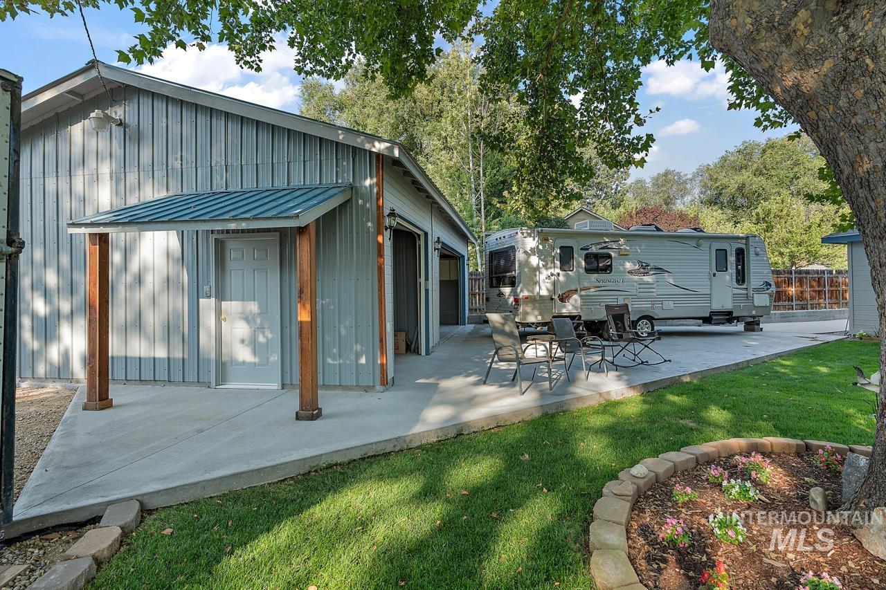 Back of house with board and batten siding, a yard, and a metal roof