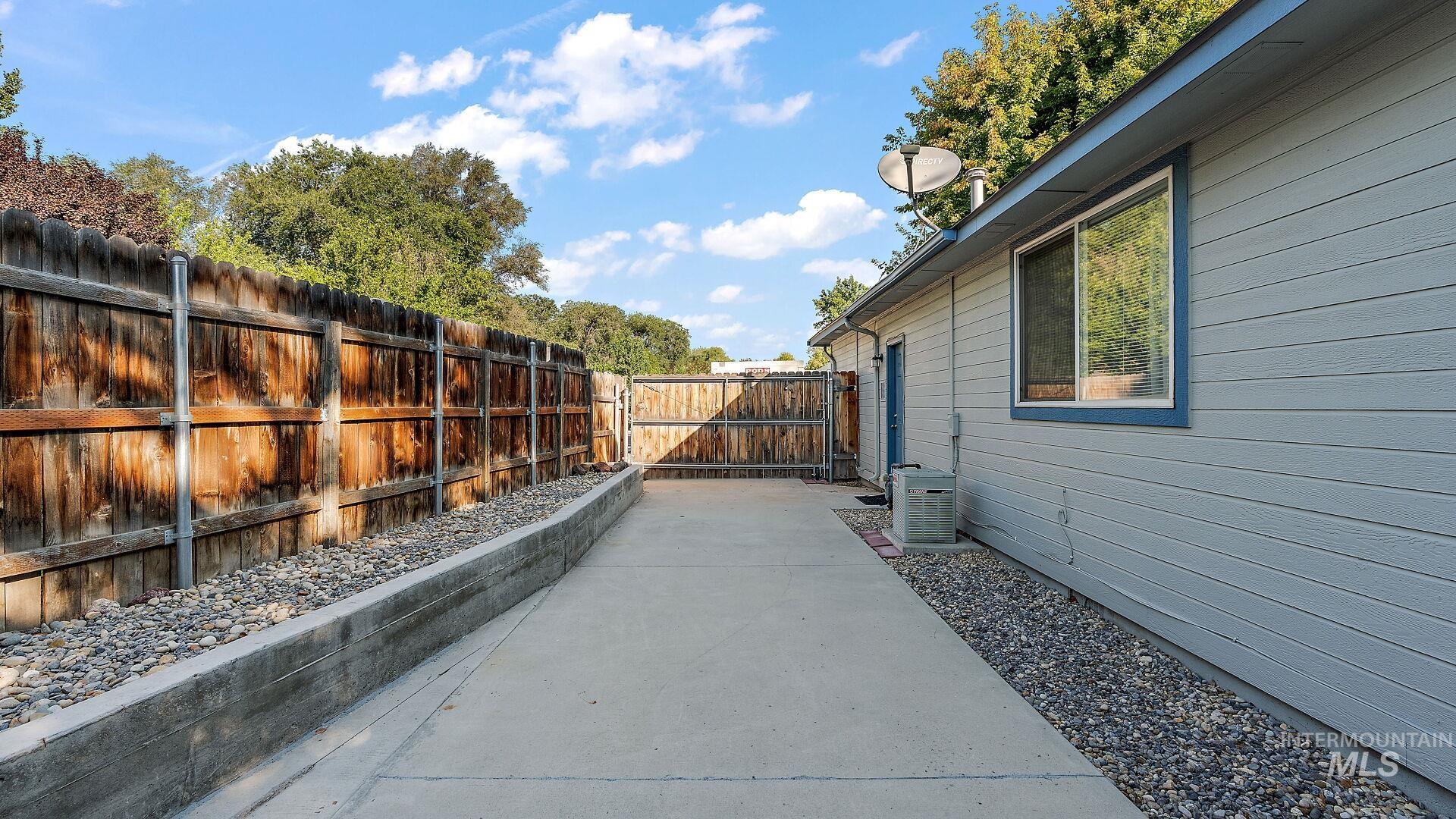 Fenced backyard with a gate and a patio