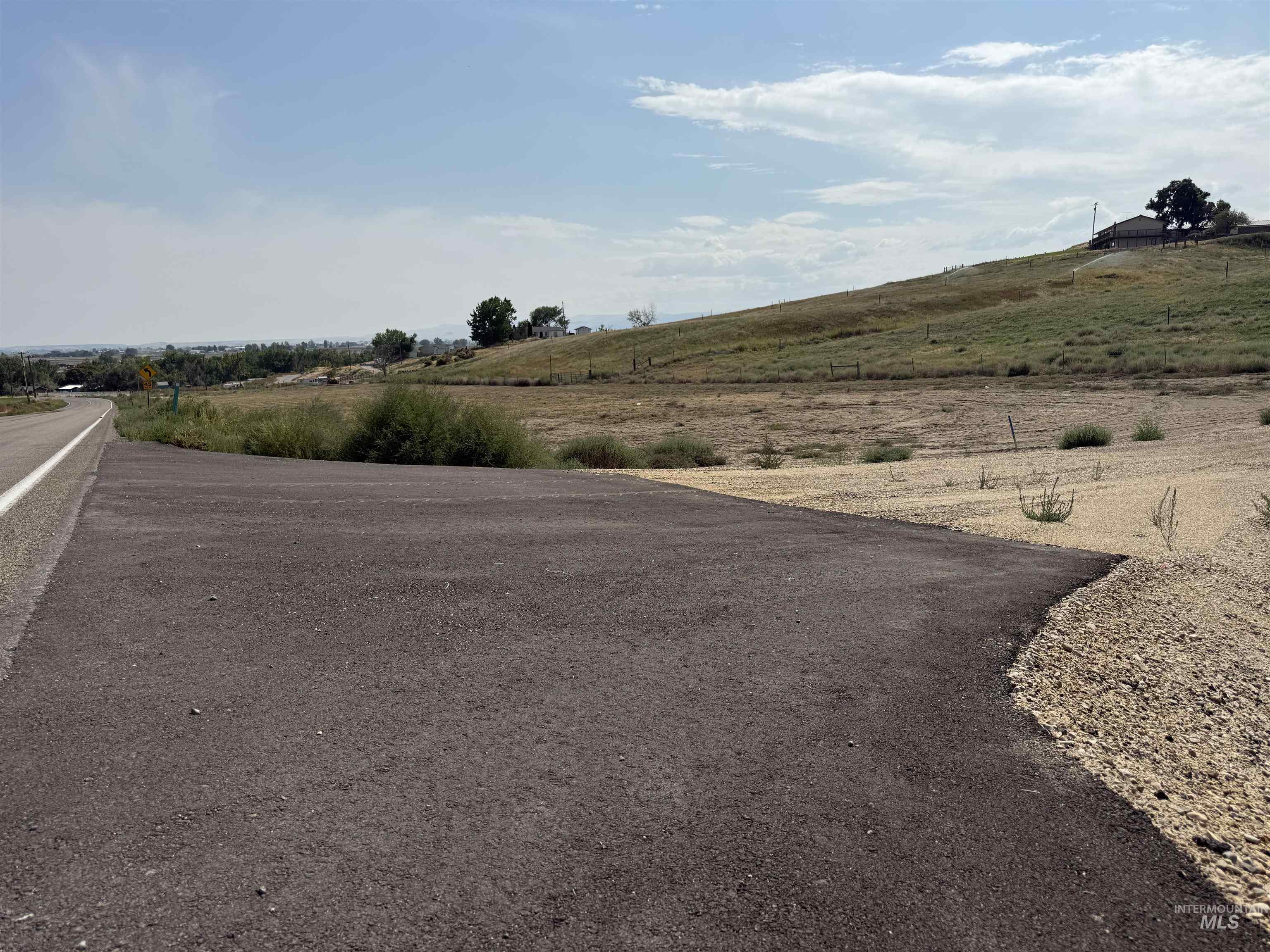 View of asphalt street with a rural view