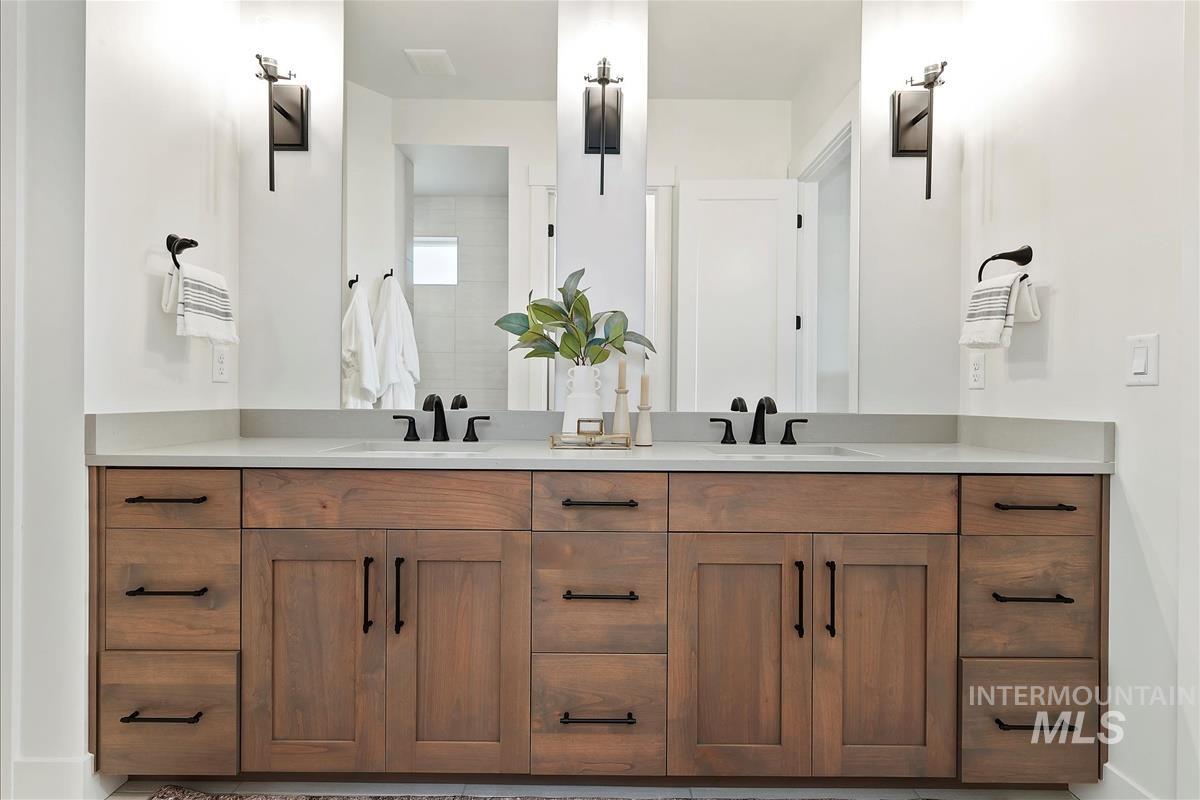Full bath with double vanity and baseboards