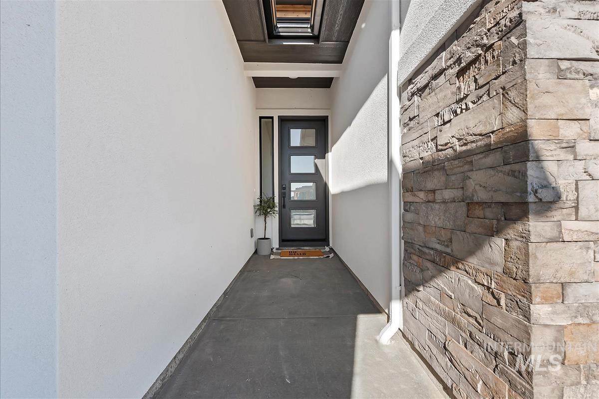 View of exterior entry featuring stucco siding and stone siding