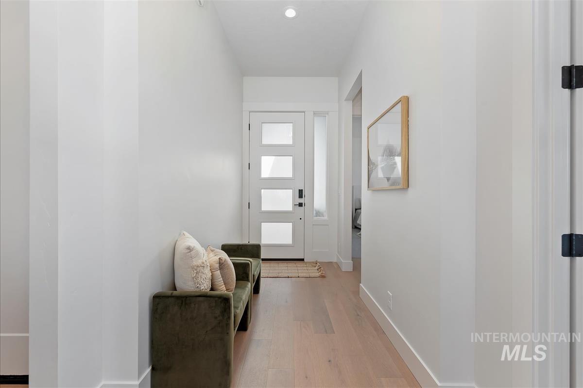 Doorway with wood finished floors and recessed lighting