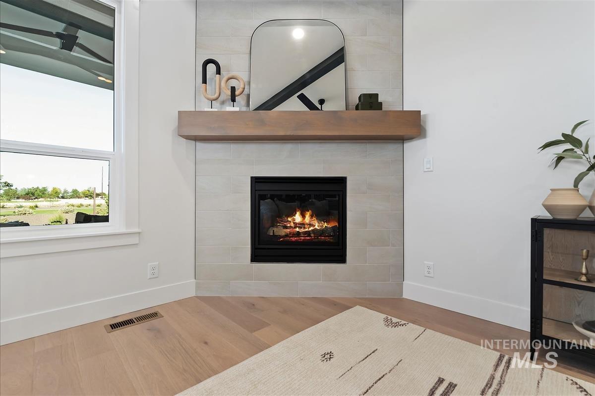 Detailed view of wood finished floors and a fireplace