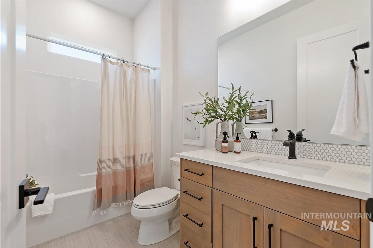 Full bath with shower / bath combo with shower curtain and vanity
