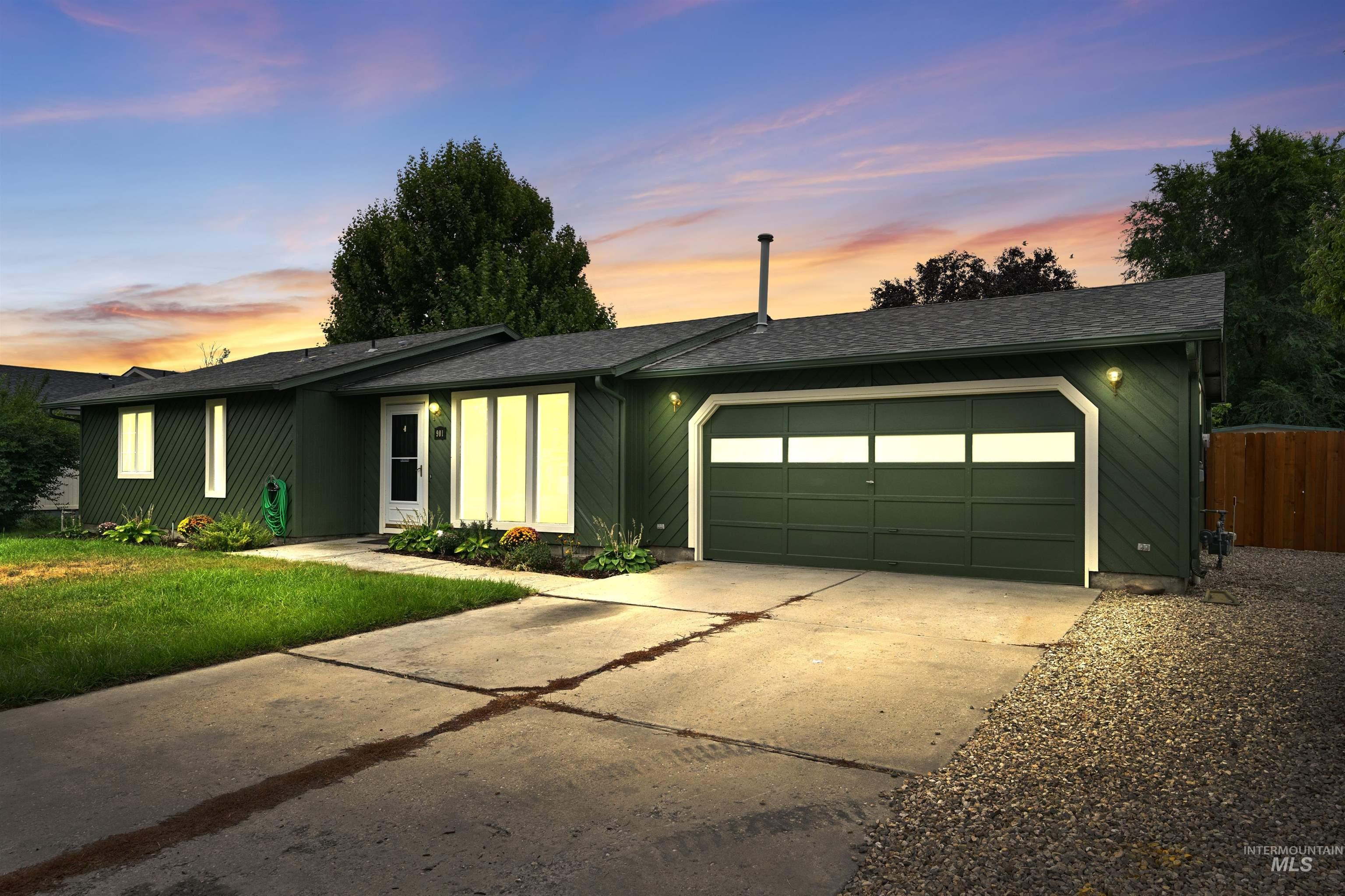 View of front of home with driveway, a garage, and a shingled roof
