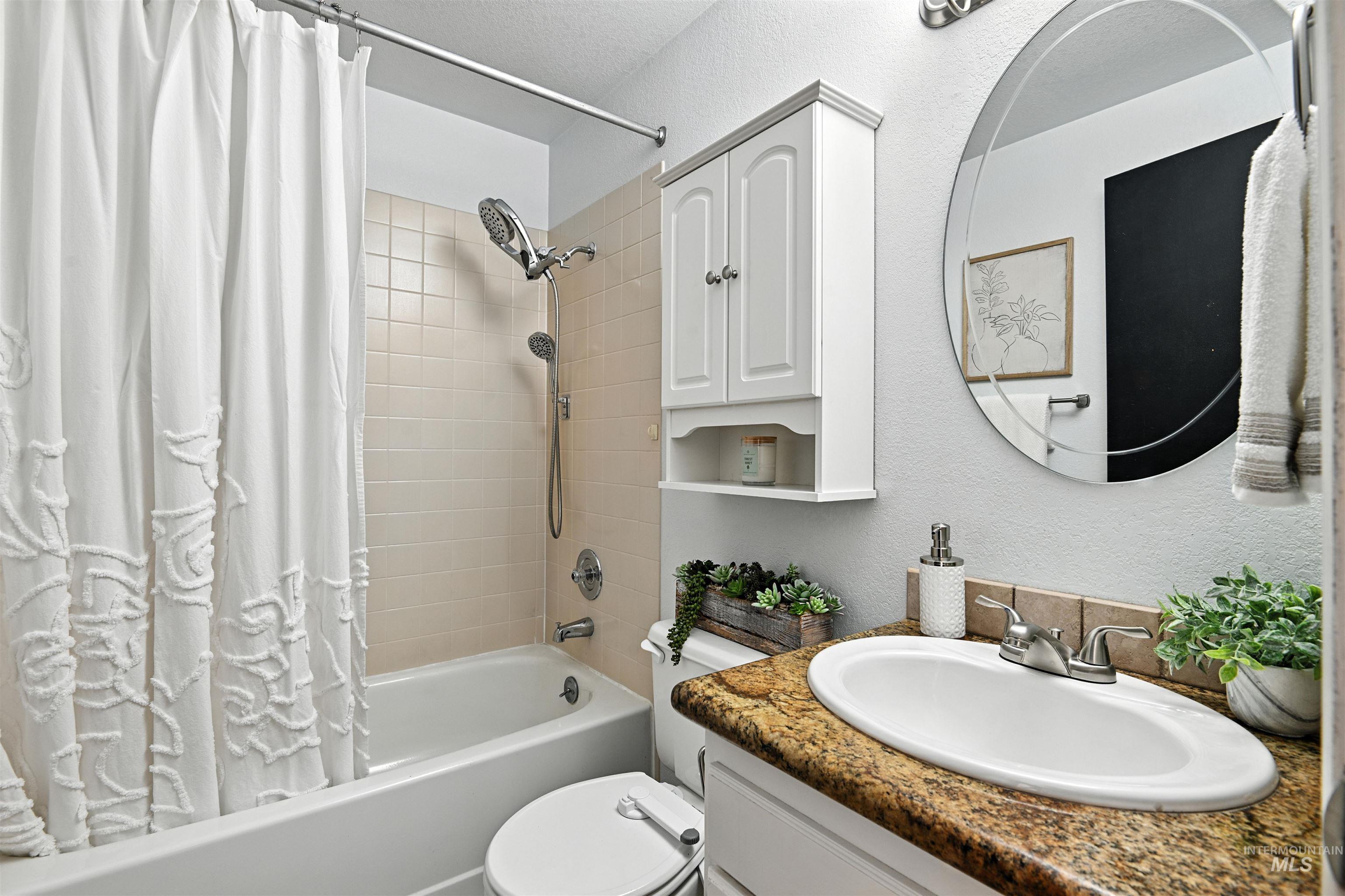 Full bathroom with shower / tub combo with curtain and vanity