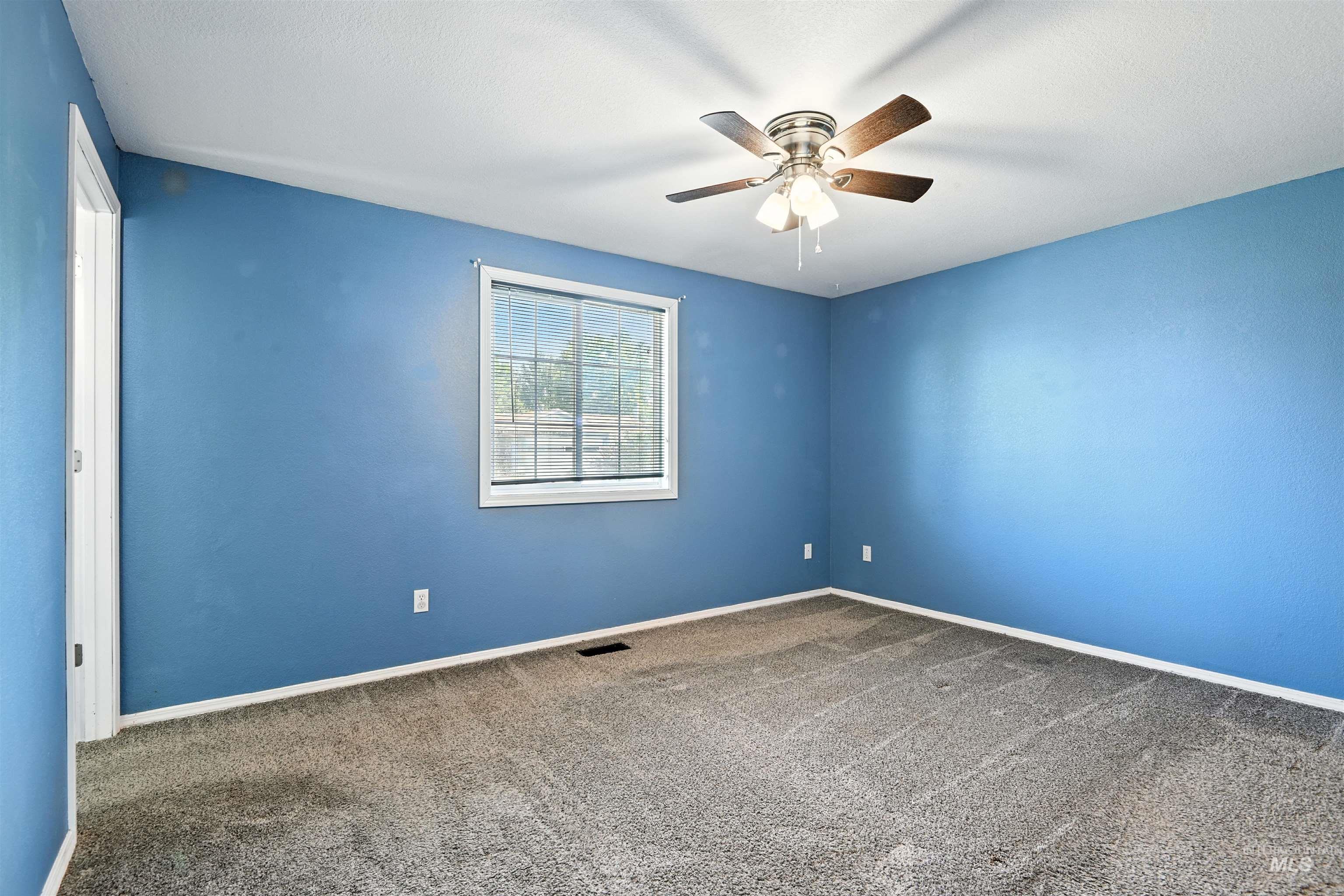 Spare room with carpet floors and a ceiling fan