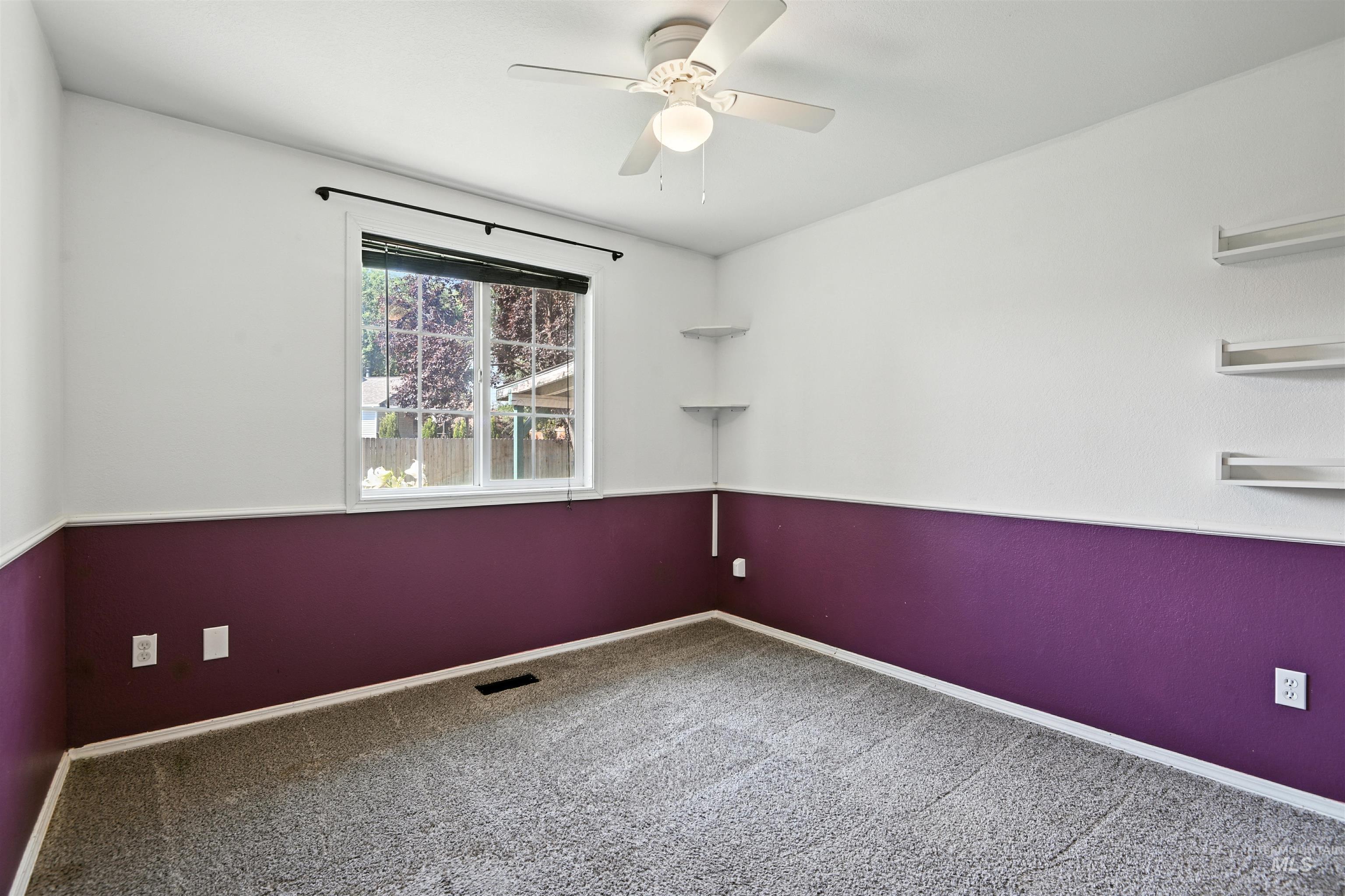 Empty room featuring ceiling fan and carpet floors