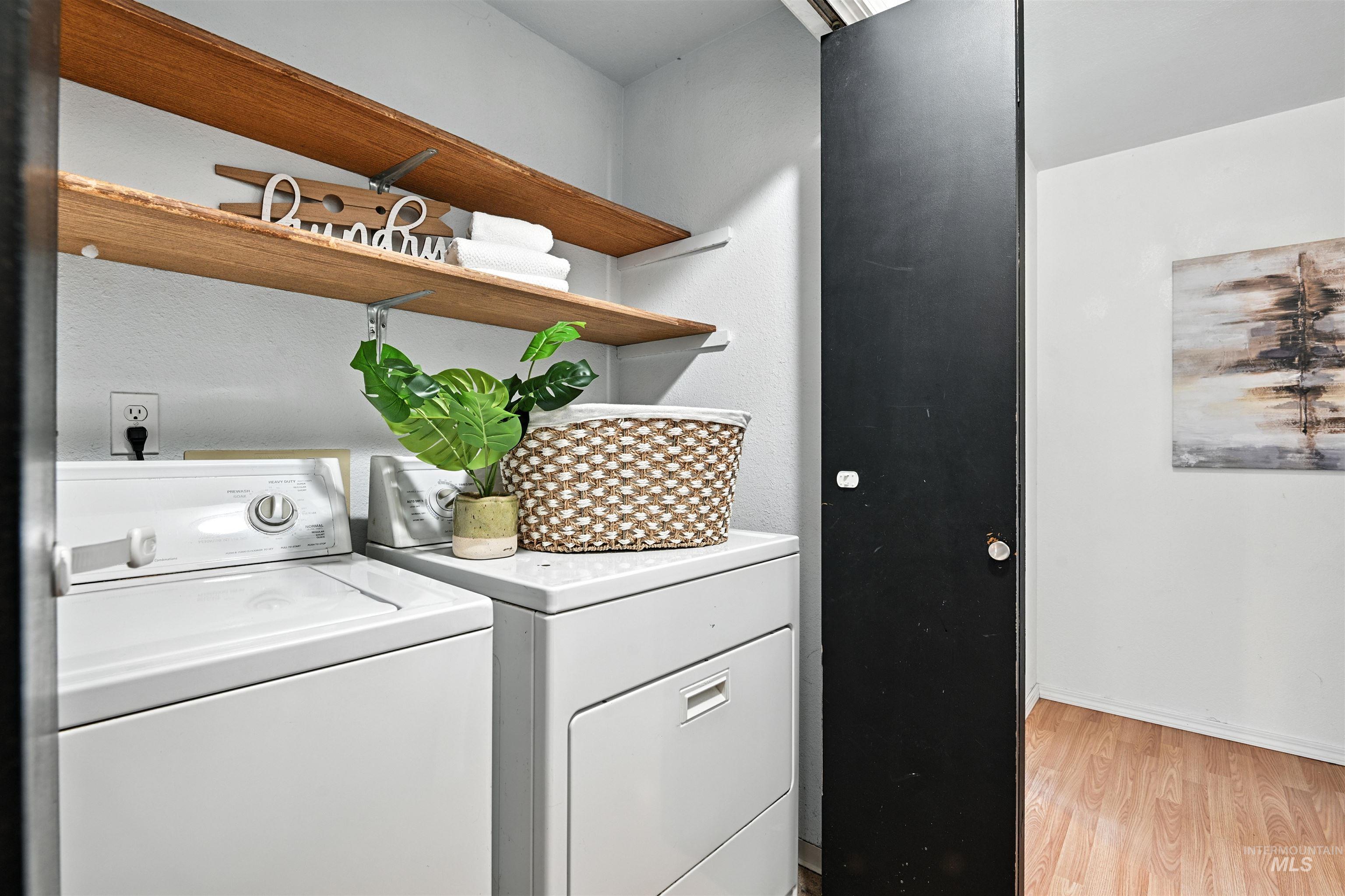 Laundry area featuring washer and dryer and light wood-style floors