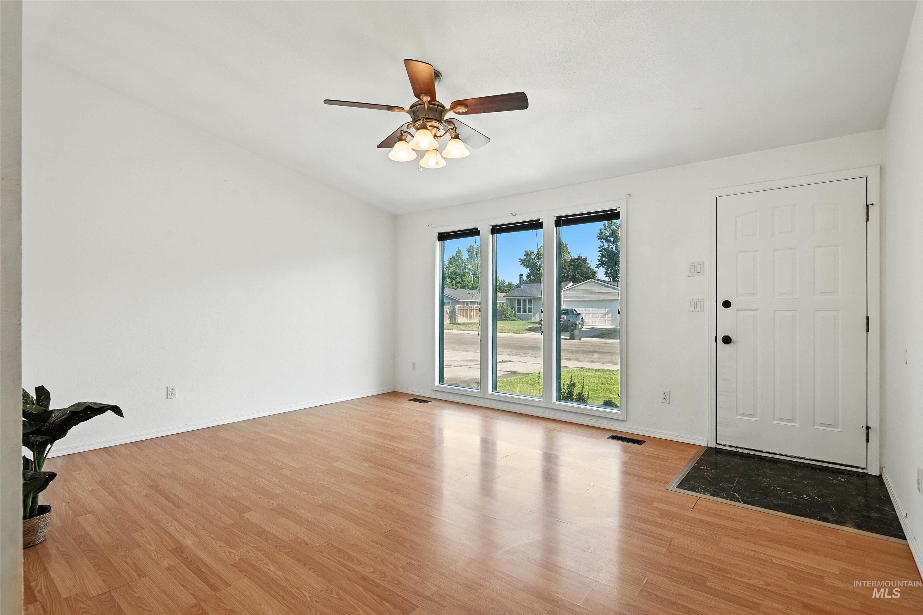 Entryway featuring ceiling fan, wood finished floors, and vaulted ceiling