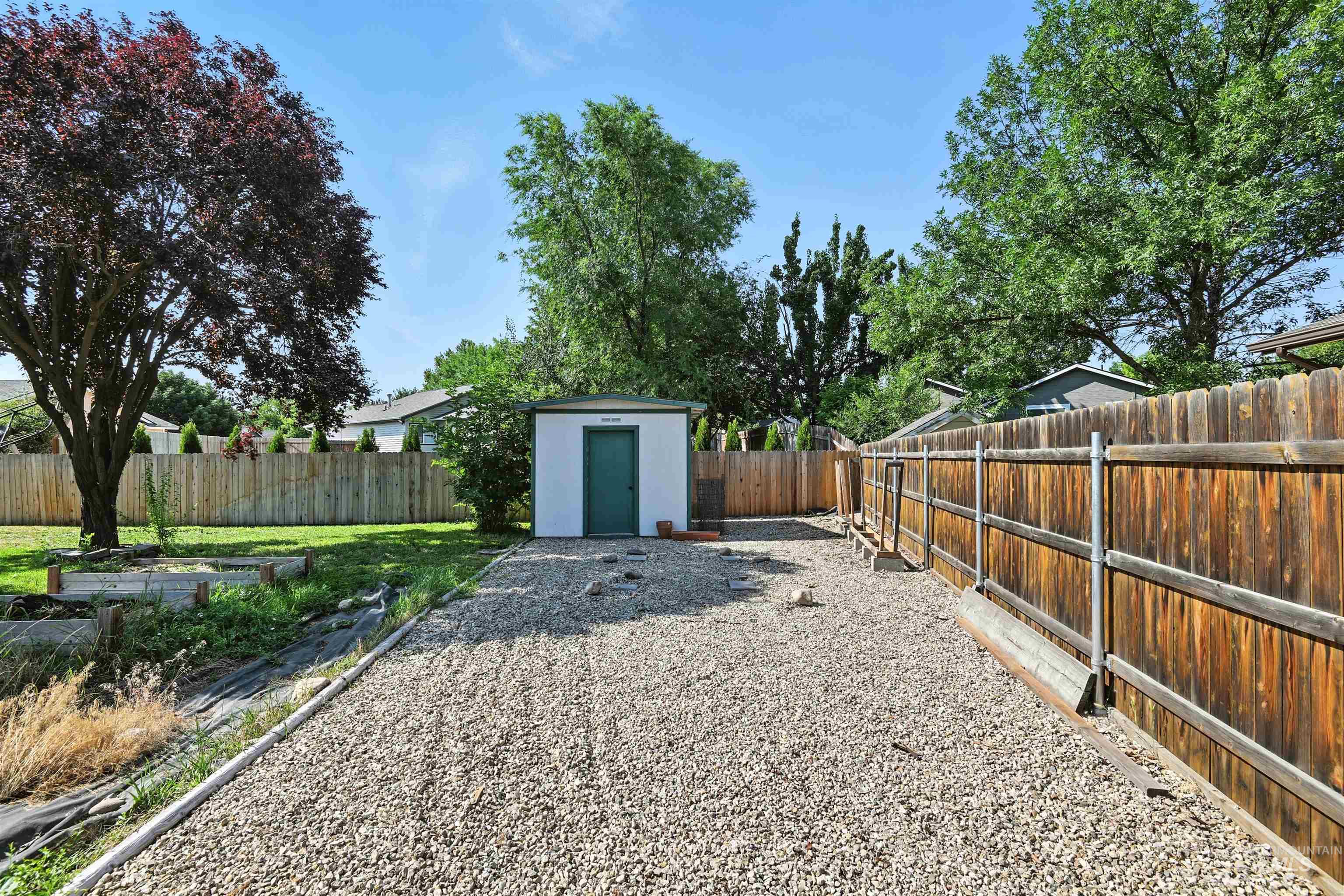 Fenced backyard with a storage shed