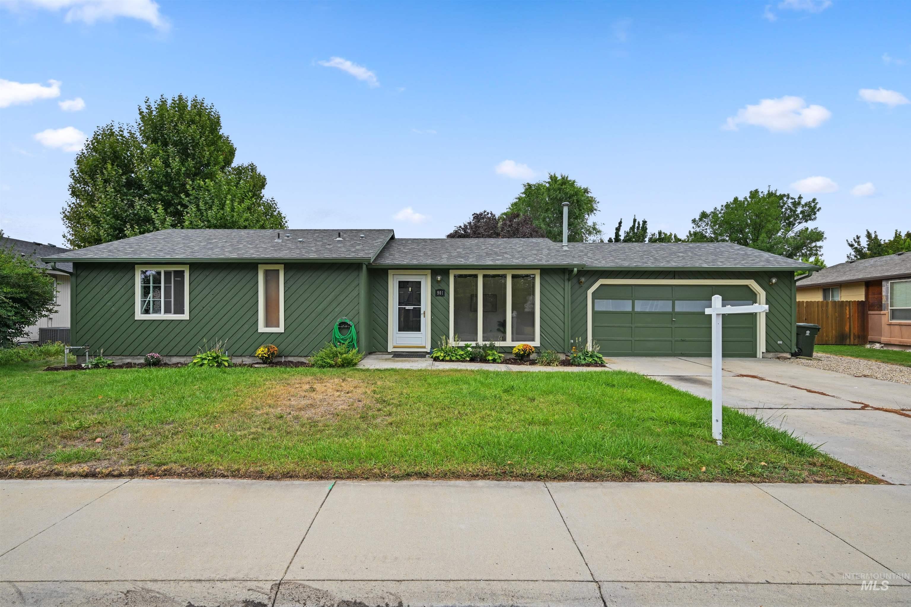 Single story home with driveway, a garage, and roof with shingles
