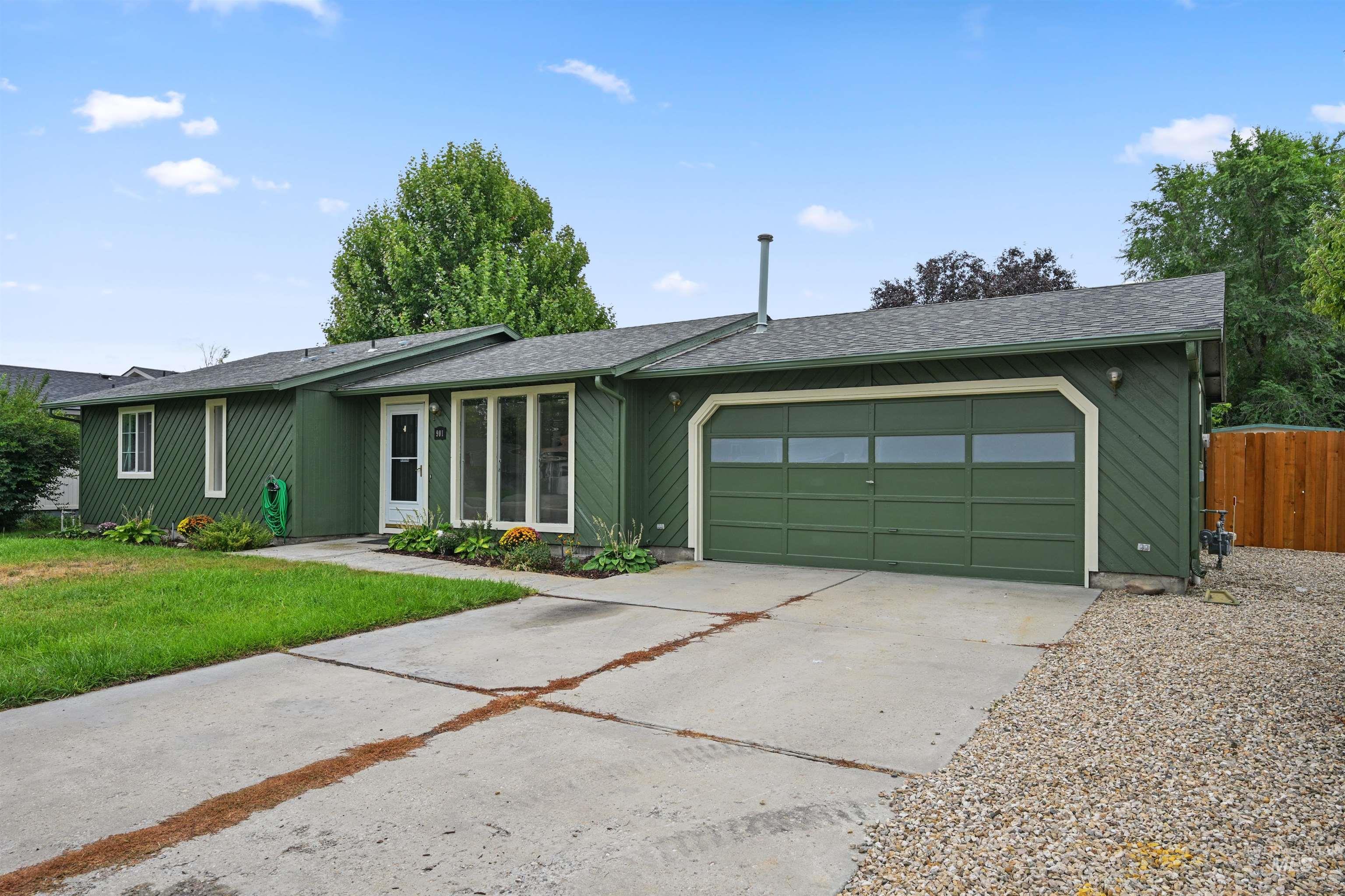 View of front of house with roof with shingles, driveway, and an attached garage