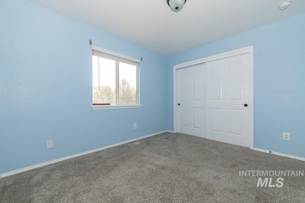 Unfurnished bedroom featuring carpet and a closet