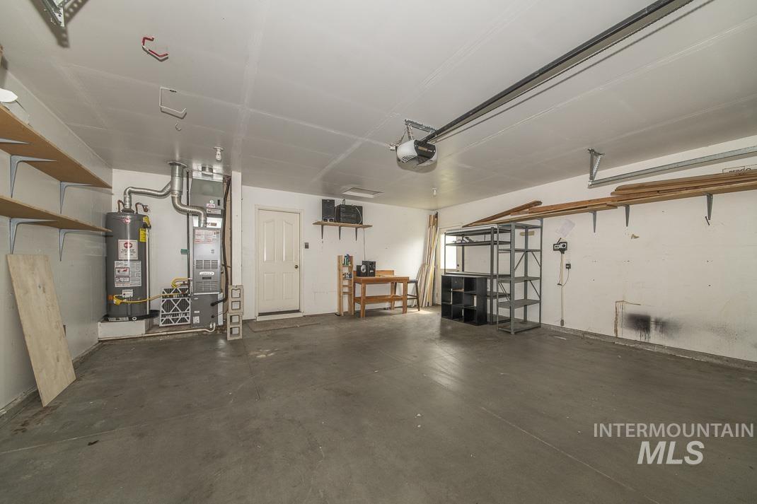 Garage featuring water heater and a garage door opener