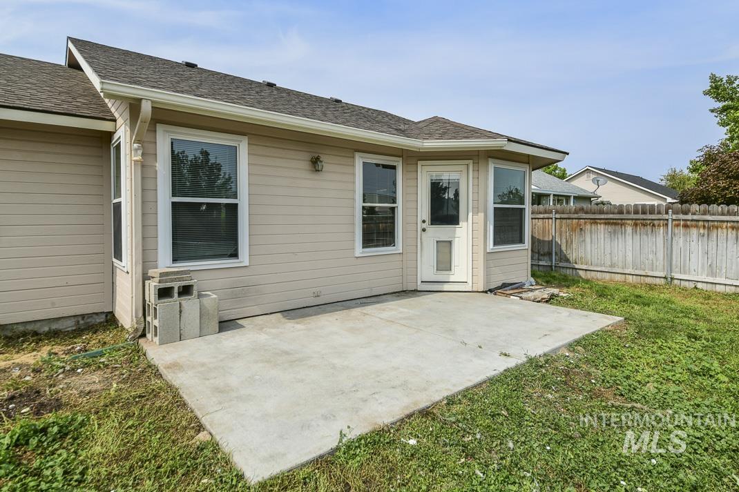 Back of house featuring a patio and a shingled roof
