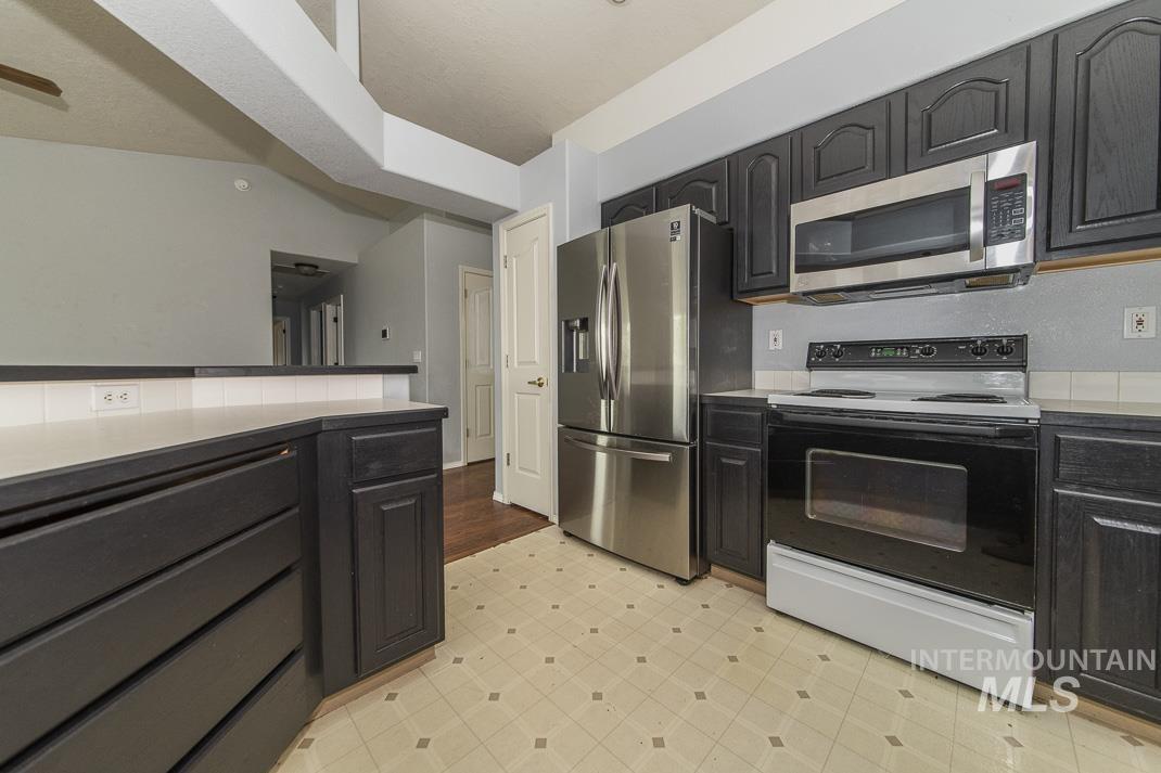 Kitchen featuring appliances with stainless steel finishes, light floors, and light countertops