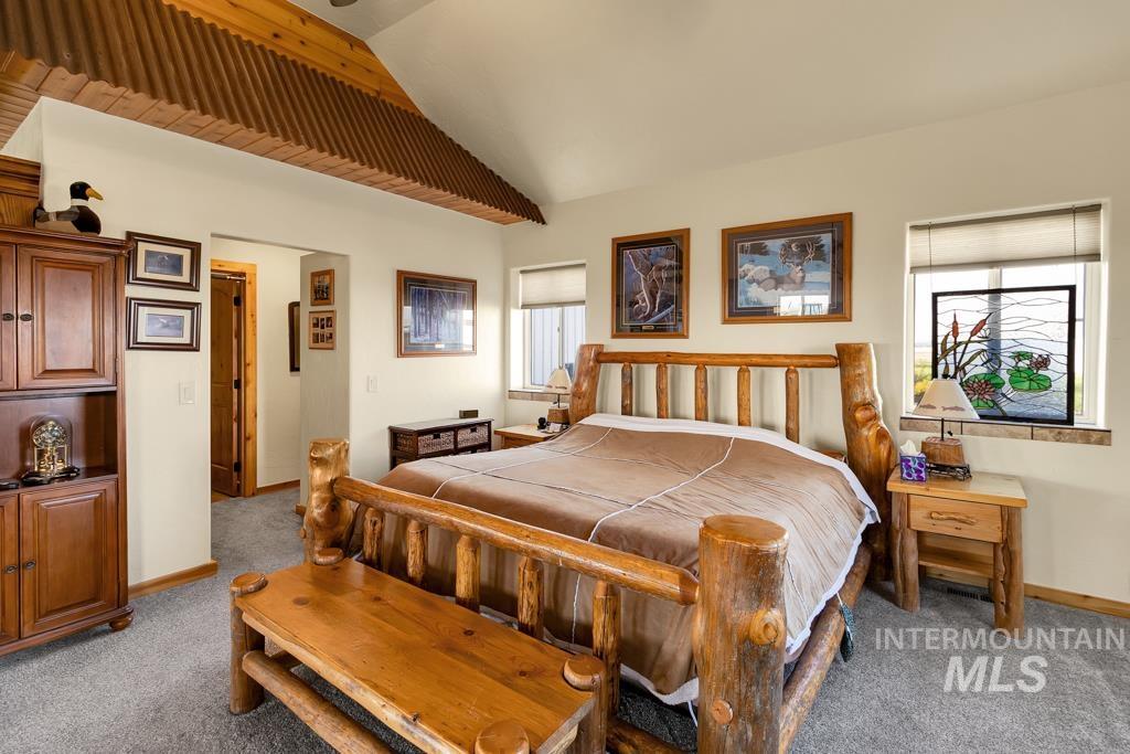 Bedroom with light carpet, lofted ceiling, and ceiling fan
