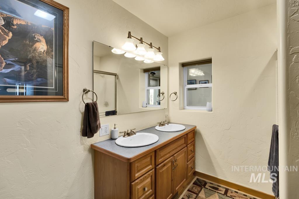 Full bathroom with a textured wall and double vanity