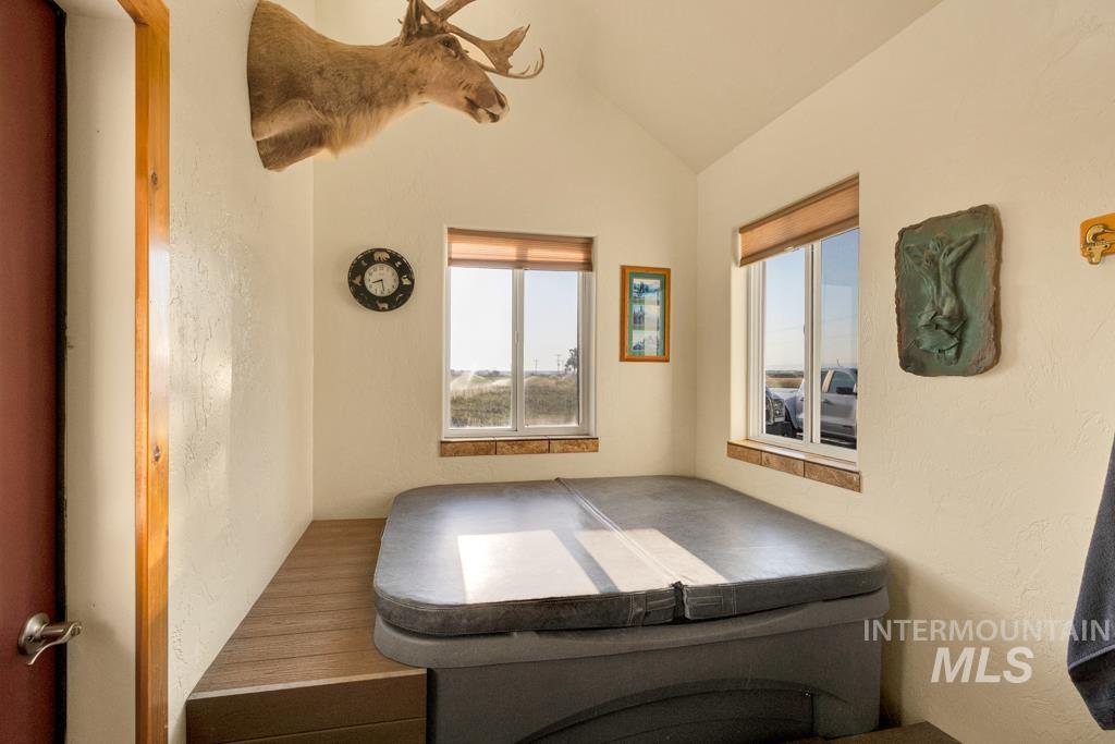 Interior space featuring a jacuzzi, vaulted ceiling, and healthy amount of natural light
